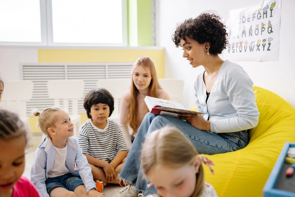 An image of a woman reading a book to the kids