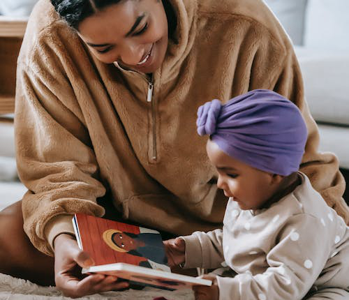 An image of a mother and kid with a book
