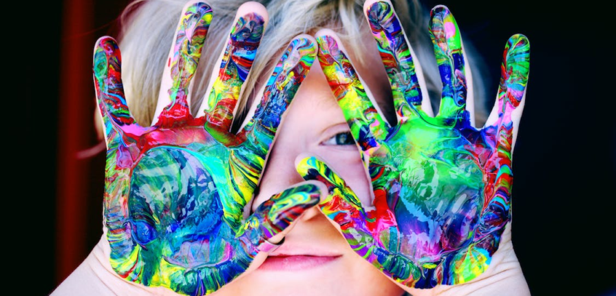 Multicolor paint on a child’s hands