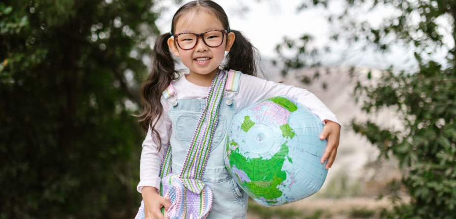 A Smiling Girl Holding an Inflatable Globe