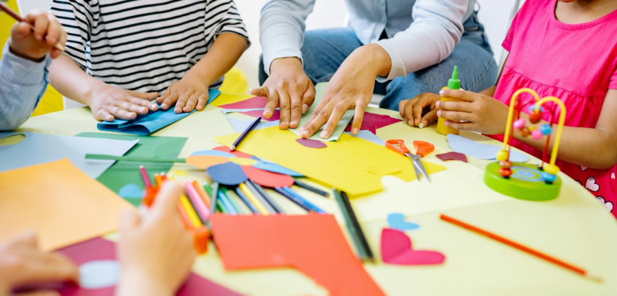 Kids playing with colored papers on a table