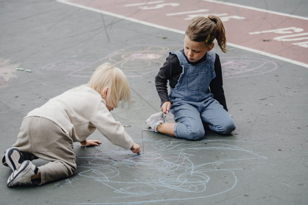 Kids playing outdoors with colored chalk