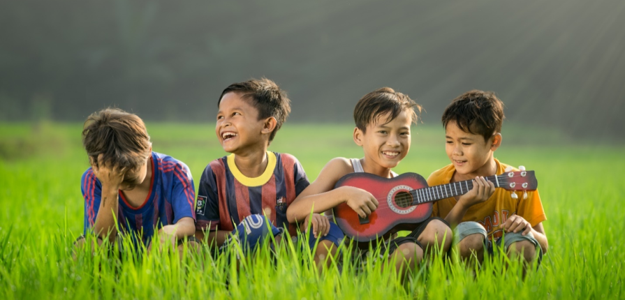 Kids laughing and playing music outdoors