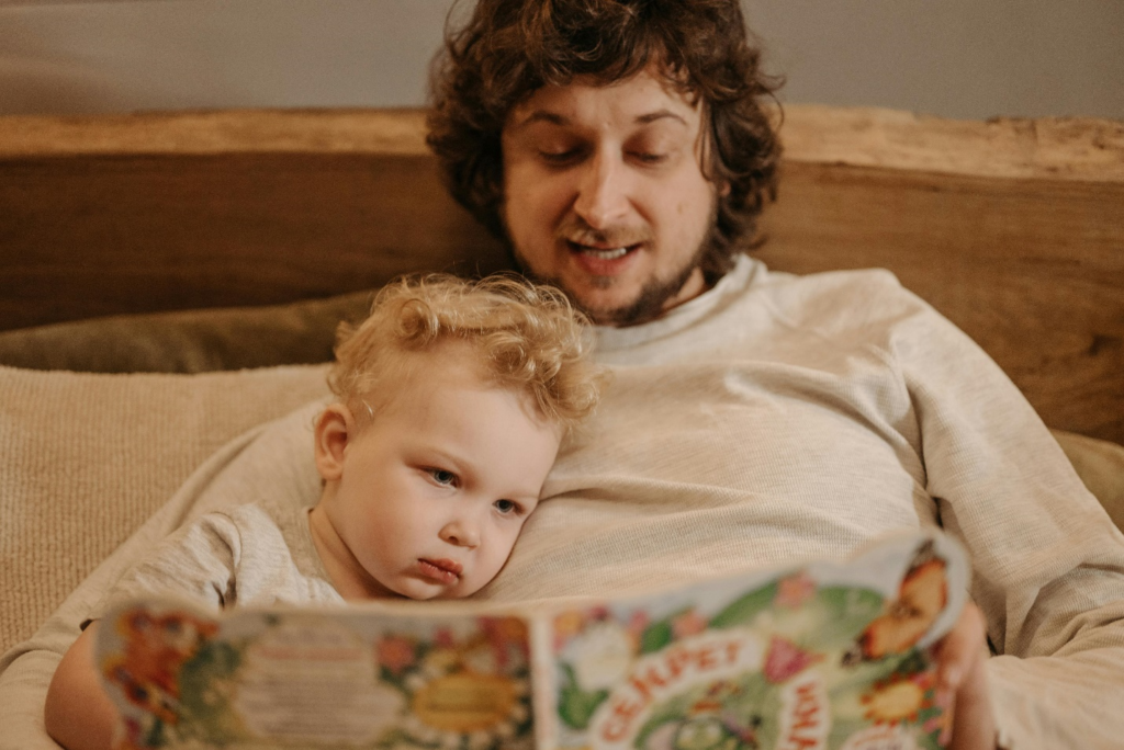A father reading to his infant, creating tender and cherished moments through a bedtime story for young children.