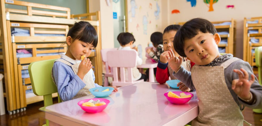 Three toddlers enjoying lunchtime at Montessori Preschool in Katy.